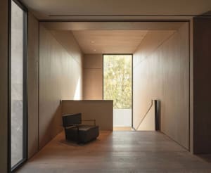 A minimalist interior design featuring wooden walls and large glass window.