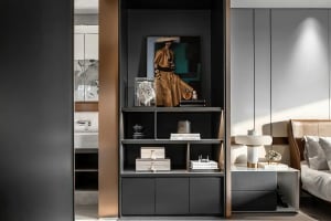 A modern bedroom featuring a black metallic shelf with a model, books, and decorative items.