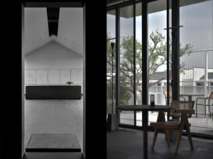 A modern interior design featuring a large glass window with a view of greenery.