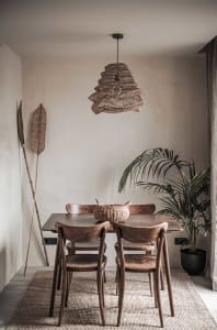 A minimalist interior design with wooden furniture and a rattan light fixture.