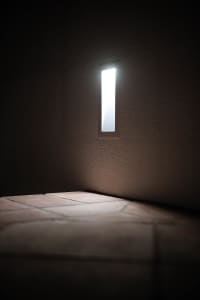 A minimalist room with elegant lighting and tiled floor.