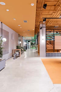 Industrial-style restaurant interior featuring concrete walls, metal accents, and wooden elements.