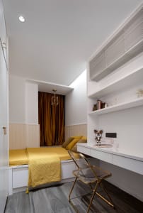 Modern minimalist bedroom featuring white and yellow decor with built-in desk and cabinetry.