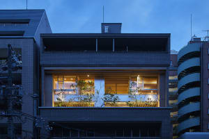 Modern residential building exterior with brick facade and illuminated windows.
