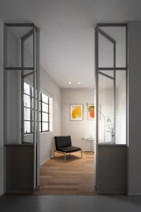 Industrial-style living room with metal-framed glass doors, minimalist furniture, and modern artwork.
