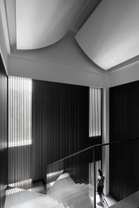 A minimalist staircase with glass railings and a geometric design.