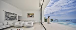 A modern living room featuring a glass ceiling and panoramic ocean view.