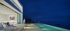 Modern residential exterior featuring glass elements at dusk.
