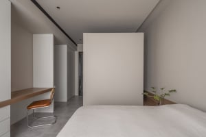 Minimalist bedroom with neutral-toned furniture and walls.