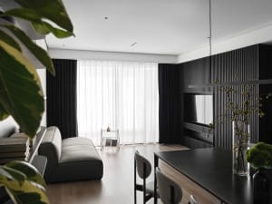 Modern living room featuring leather and glass furniture with minimalist design and wooden flooring.