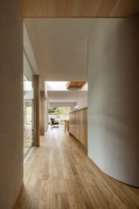 A modern interior with wooden flooring, light-colored walls, and a skylight.