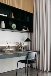 A minimalist study space featuring a marble desk, metal chair, and minimalist decor.