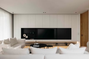 Modern living room with minimalist design and white furniture.