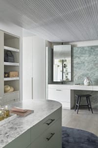 A modern utility room featuring marble countertops and a white wooden cabinet.