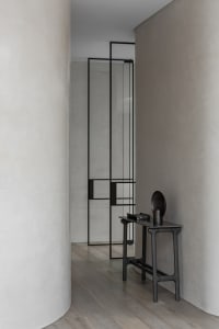 A sleek, modern console table with a minimalist design, featuring a metal base and polished metal surface.