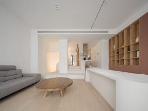 A modern minimalist living room featuring a wooden coffee table.