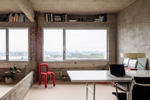 A minimalist office space featuring industrial concrete elements.