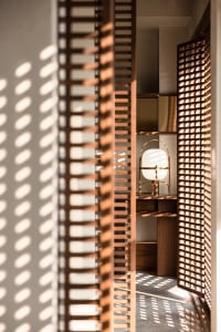 A modern retro lamp with a wooden frame, positioned in a minimalist setting with light-colored walls and a wooden floor.