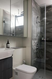 Modern residential bathroom featuring gray marble tiles and a sleek, contemporary design.
