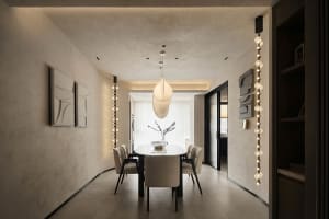 Modern dining room with concrete and glass materials and elegant lighting fixtures.