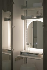 A modern vanity with white materials and illuminated lighting.