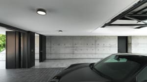 Modern minimalist car garage with concrete walls and floors, featuring a sleek, black sports car.