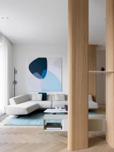 Modern minimalist living room designed with marble accents and a white interior with a floor-to-ceiling window.