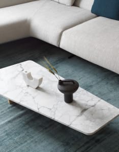 A modern marble living room with a white sofa and a marble coffee table.