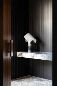 A minimalist entryway featuring a modern lamp and marble countertop