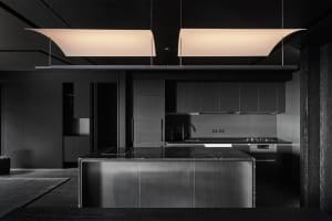 Modern kitchen with a minimalist design featuring marble countertops and stainless steel appliances.