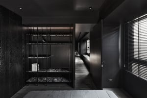 A modern bedroom featuring a black bookshelf made of metal, marble, and wood.