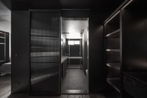 Modern bathroom featuring dark glass walls and floor, with a sleek design and minimalistic aesthetic.