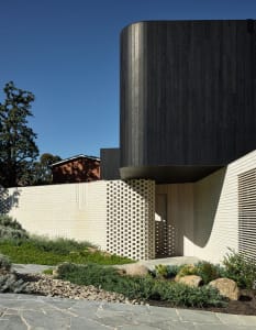 Modern residential exterior featuring brick and wood materials.