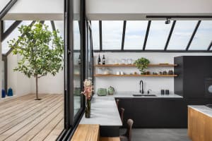 Modern industrial-style kitchen with wooden countertops, metal cabinets, and glass shelving.