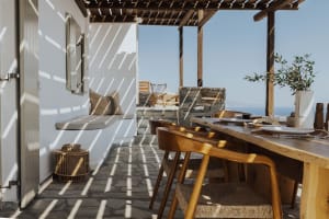 Industrial-style wine bar with ocean view seating and wooden furniture.