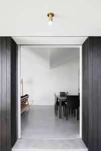 Modern, interior design featuring a room with concrete flooring and minimalist furniture.