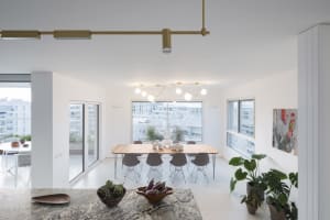 Contemporary dining room featuring wooden furniture, glass windows, and potted plants.