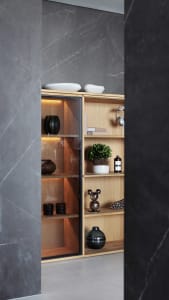 Modern interior design featuring wooden shelves and glass vases with plants and books.