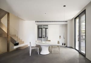 A modern dining room features a white table and chairs, with a sleek, minimalist design.