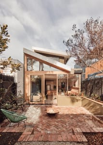 Modern exterior view of a home featuring brick, glass, and motion elements.