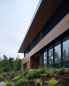 Modern residential exterior with wooden shingles and large glass windows