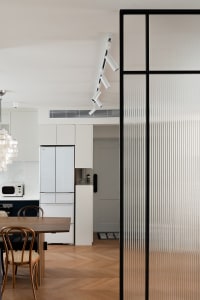 Modern residential kitchen featuring a glass panel with geometric design and contemporary furniture.