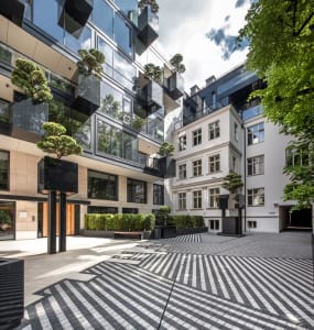 A modern commercial space with a glass facade and geometric courtyard.