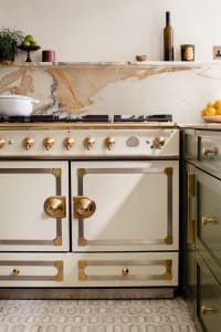 A modern kitchen featuring marble countertops and brass hardware