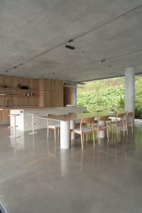 A minimalist residential kitchen with concrete flooring and minimalistic furniture.