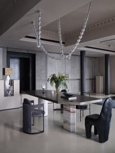 Modern restaurant interior with concrete floors and walls, minimalistic design, and contemporary art installations.
