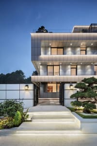 A modern residential house featuring a metal-clad facade at dusk.