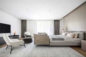 Modern minimalist bedroom featuring taupe leather furniture and beige curtains.