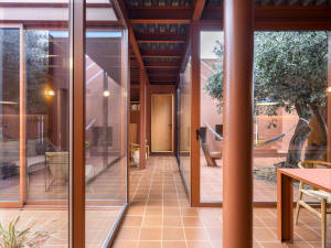 A modern patio house extension featuring a terrazzo floor, concrete columns, and large glass doors.