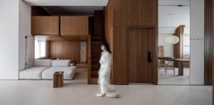 A modern living room with wooden paneling, a white sectional sofa, and a minimalist aesthetic.